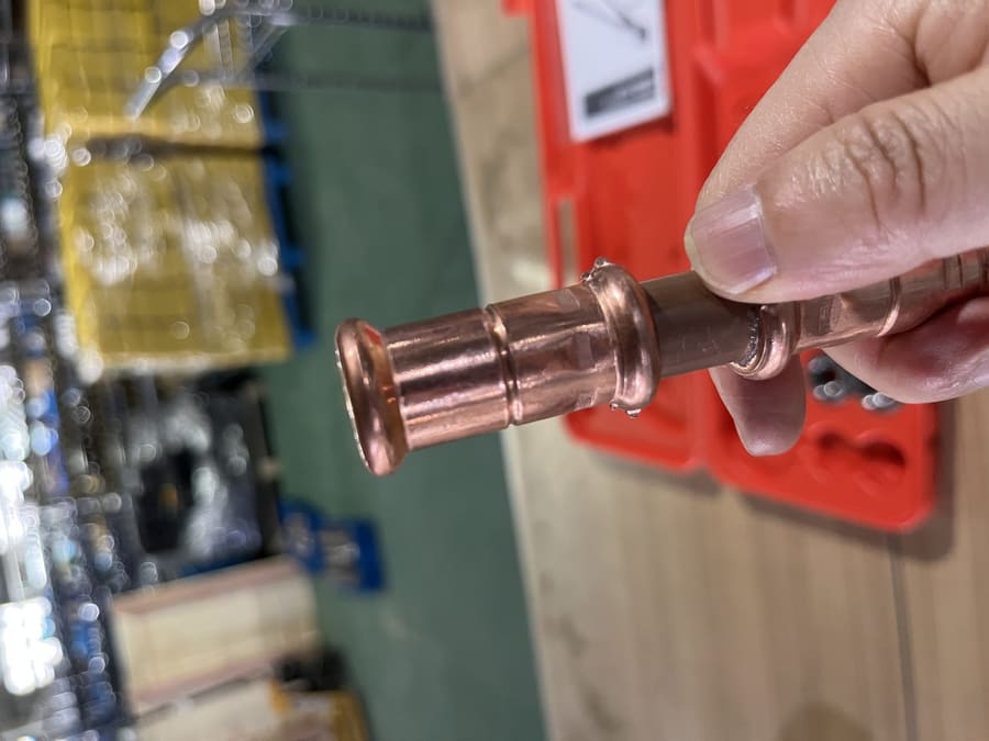 Crimped copper fitting showing burr on press joint